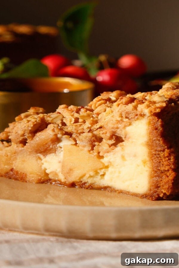 slice of apple crumble cheesecake on a beige plate.
