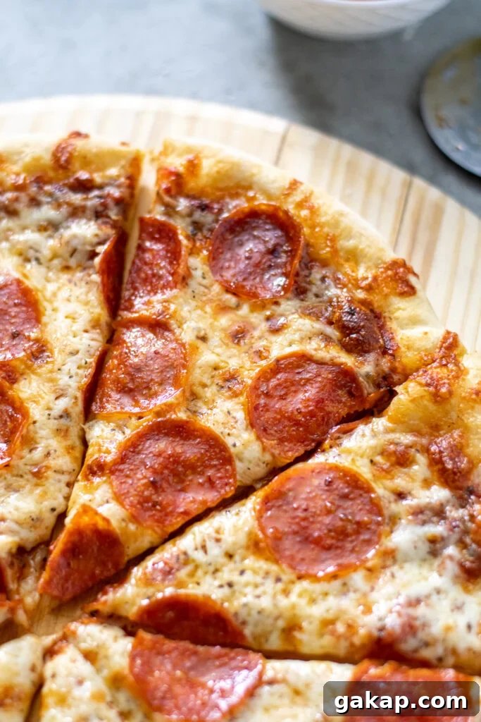 Close up of a slice of homemade pepperoni pizza showing golden cheese.