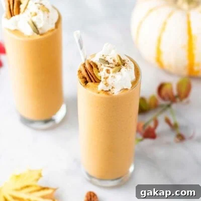 Two pumpkin spice latte smoothies with fall leaves and a pumpkin.