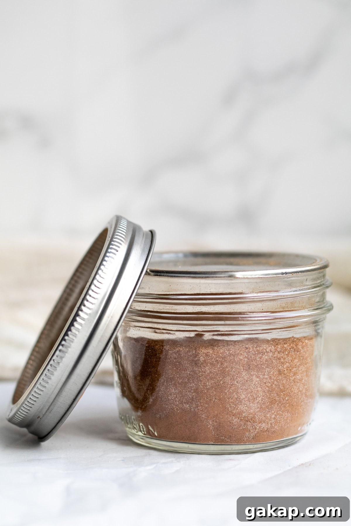 cinnamon sugar in a mason jar with the lid next to it.