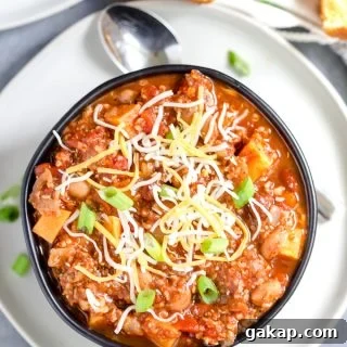 Instant Pot Turkey and Quinoa Chili Recipe 5 Instant Pot Turkey Quinoa Chili Overhead Shot on the Dish Served in a Dark Bowl with a Spoon Next to It