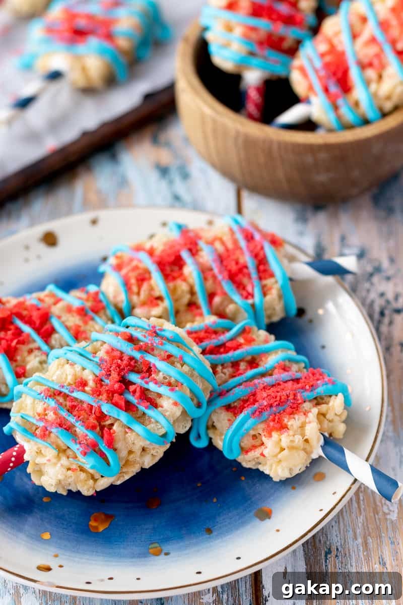 Add a little pop to your dessert table with these Fourth of July Rice Krispie Treats! These popsicle shaped crispy rice treats are a perfect no bake patriotic dessert. * GoodieGodmother.com
