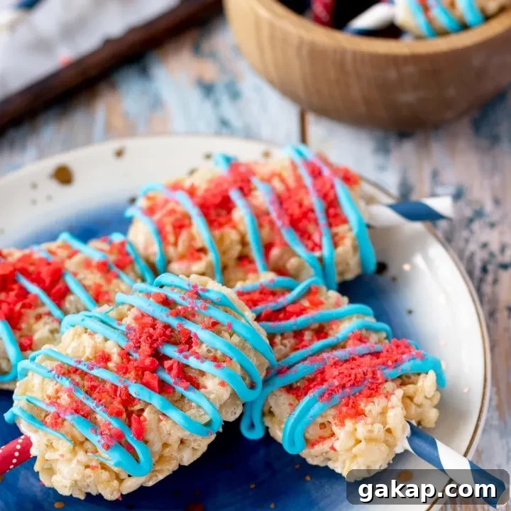Add a little pop to your dessert table with these Fourth of July Rice Krispie Treats! These popsicle shaped crispy rice treats are a perfect no bake patriotic dessert. * GoodieGodmother.com
