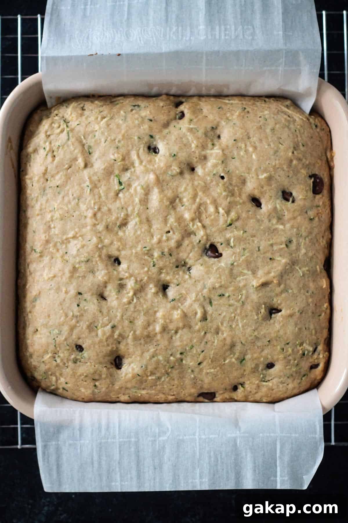 Baked chocolate chip zucchini cake in a square baking dish.
