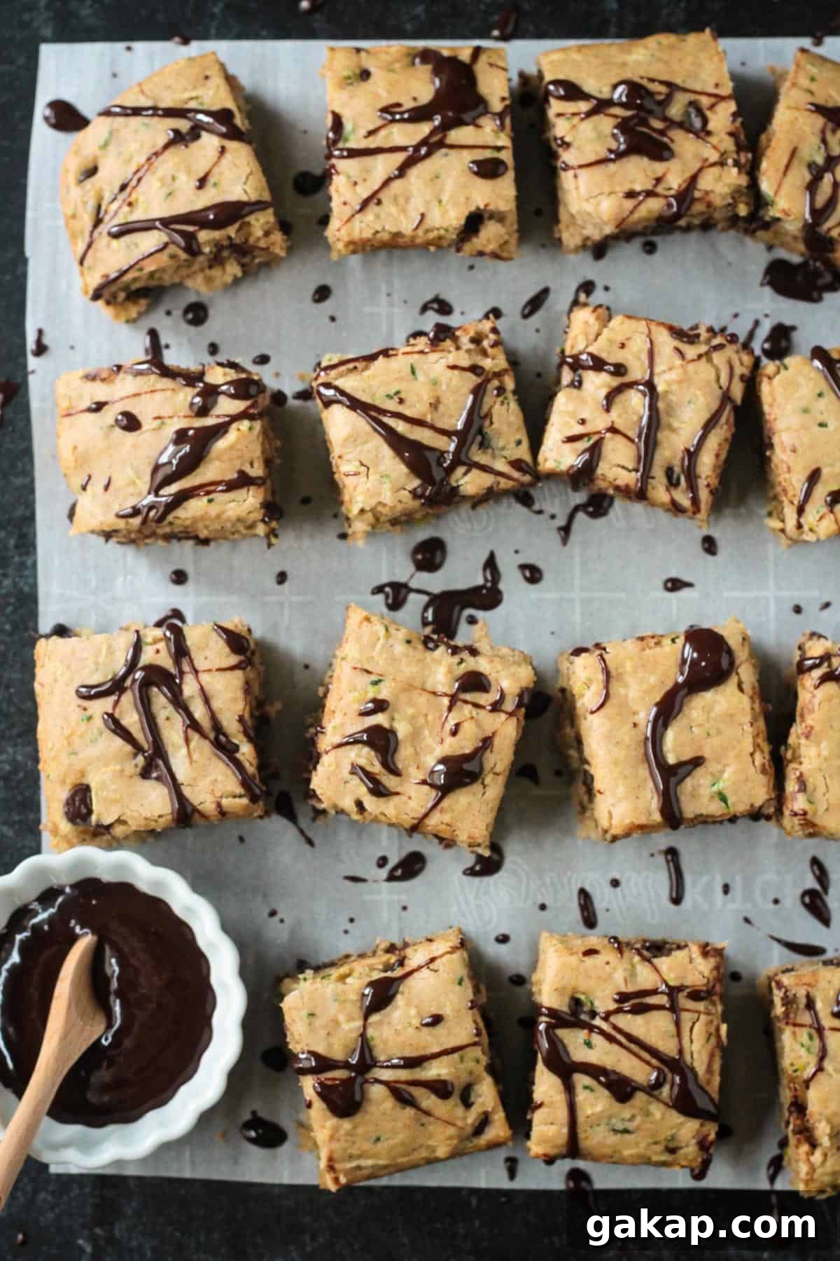 Close up of chocolate drizzle over square pieces of chocolate chip zucchini cake.
