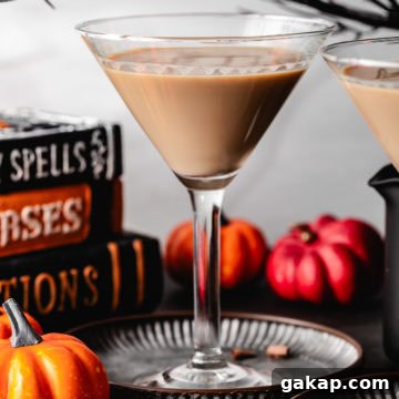 Black cat drink next to Halloween decorations.