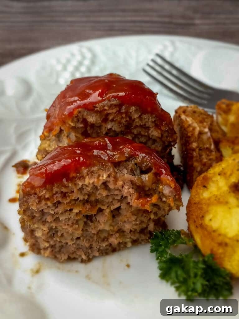 little meatloaf cut in half on a plate with potatoes