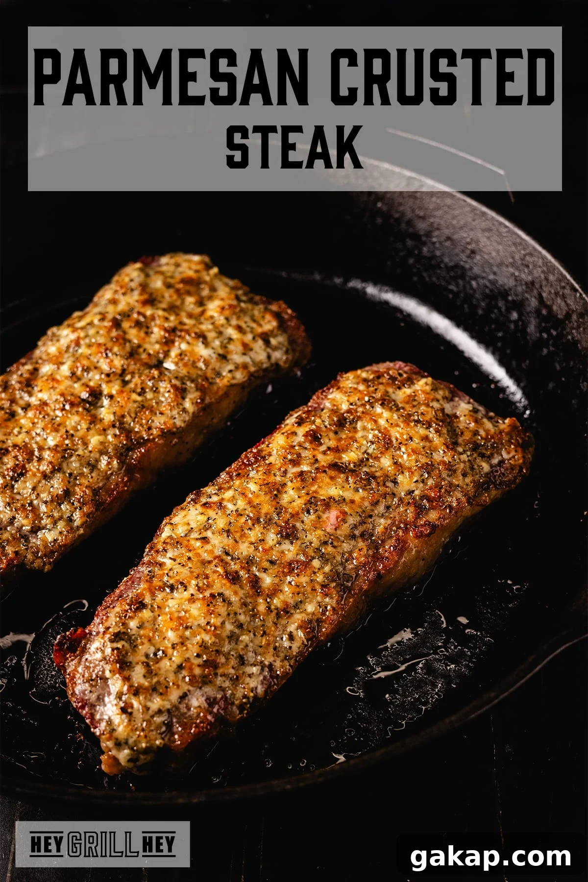 Two parmesan crusted steaks in a cast iron skillet. The text overlay reads "Parmesan Crusted Steak" at the top, and "Hey Grill Hey" at the bottom.