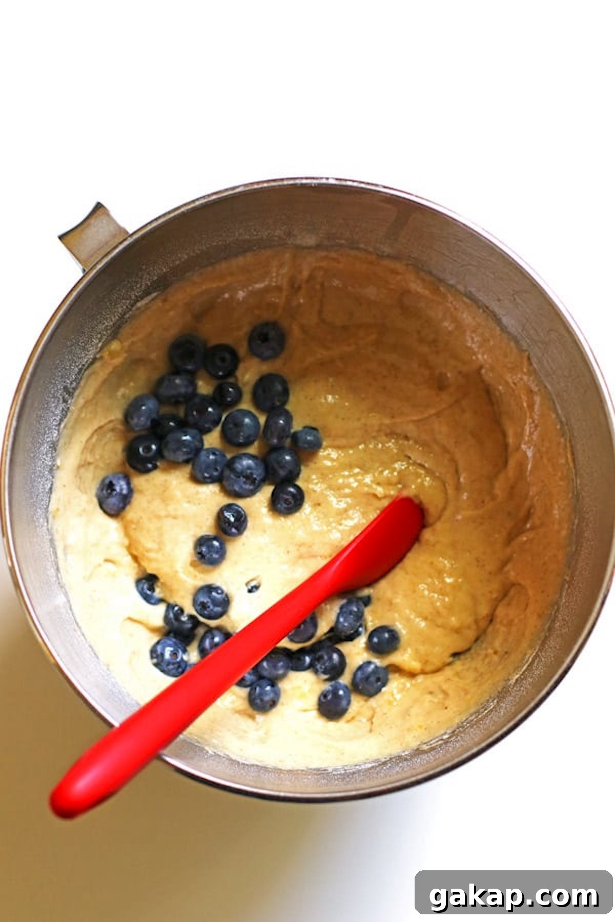 Adding in blueberries to the muffin mixture.