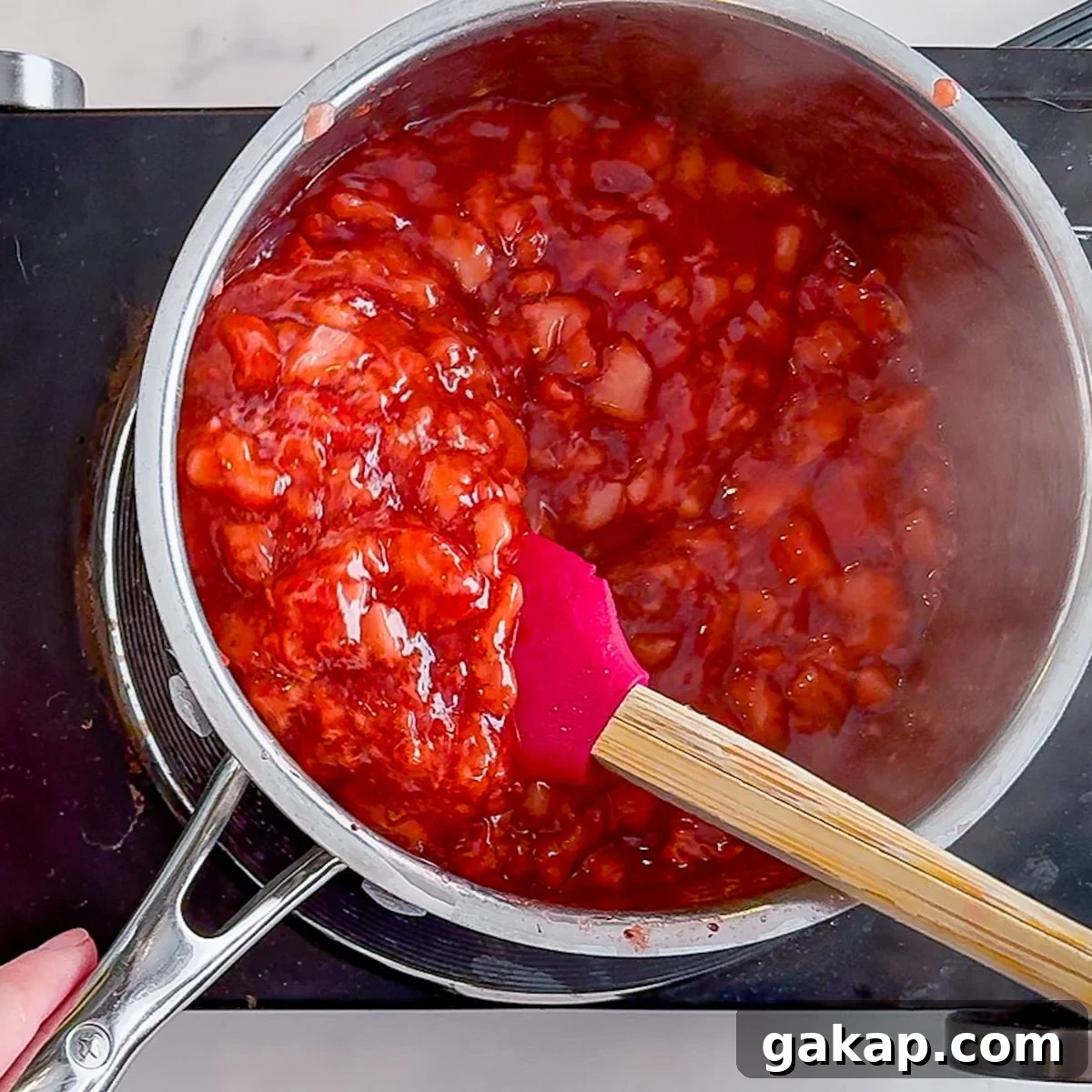 Stirring until the strawberries thicken.