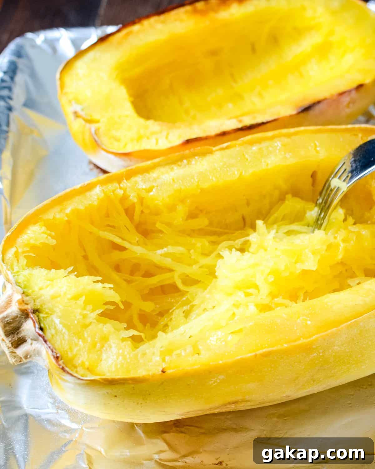 Scraping the strands of spaghetti squash using a fork.