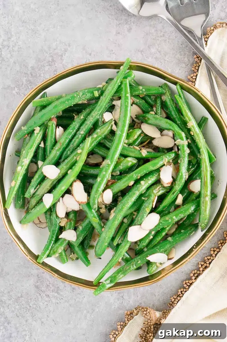 green beans with slivered almonds and garlic in a white bowl