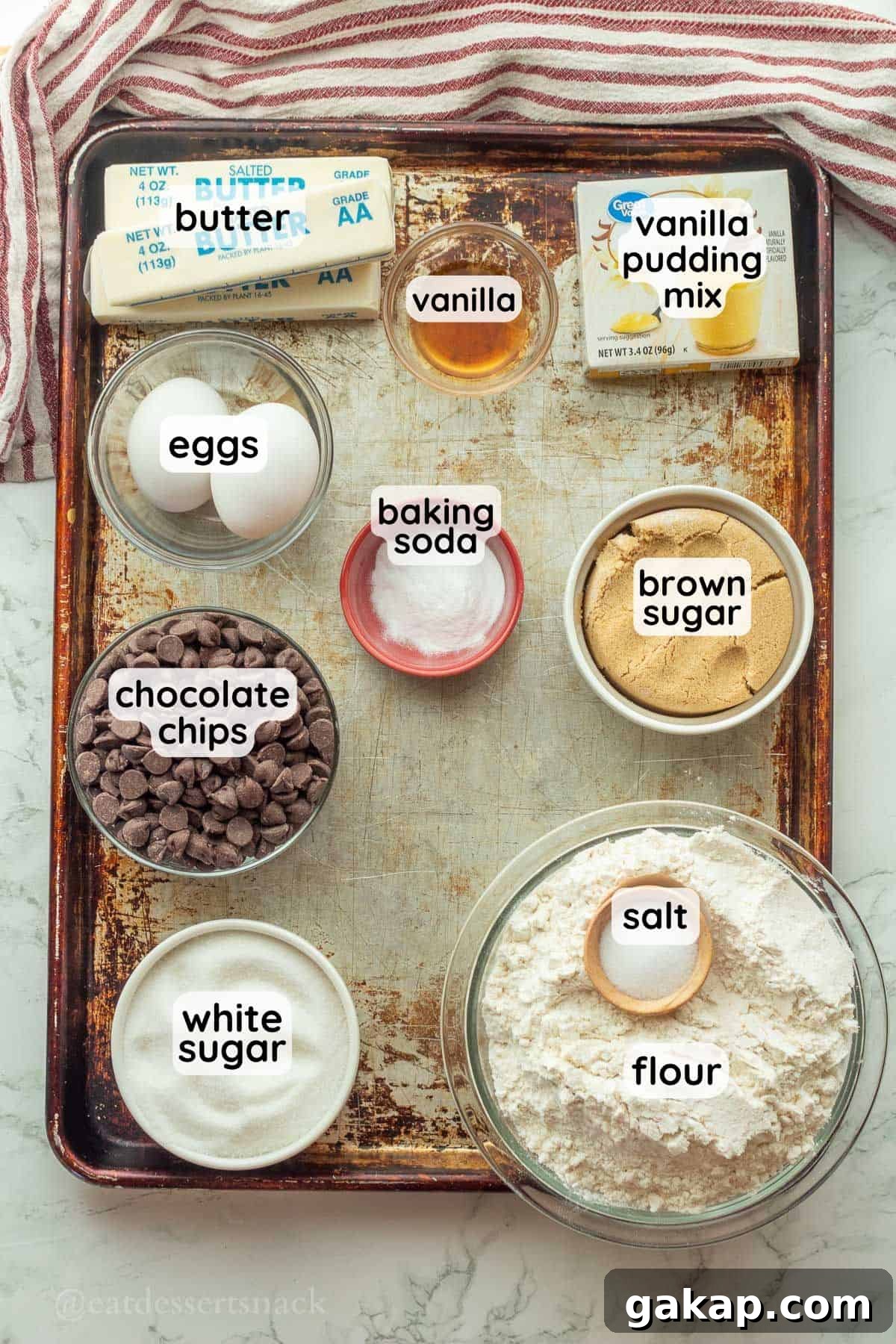 Labeled ingredients for pudding mix cookies on metal pan.