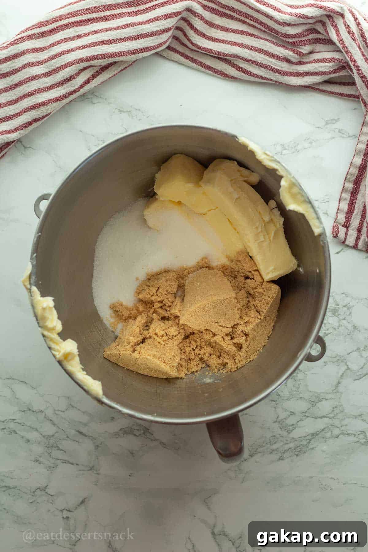 Butter, white sugar, and brown sugar in metal mixing bowl.