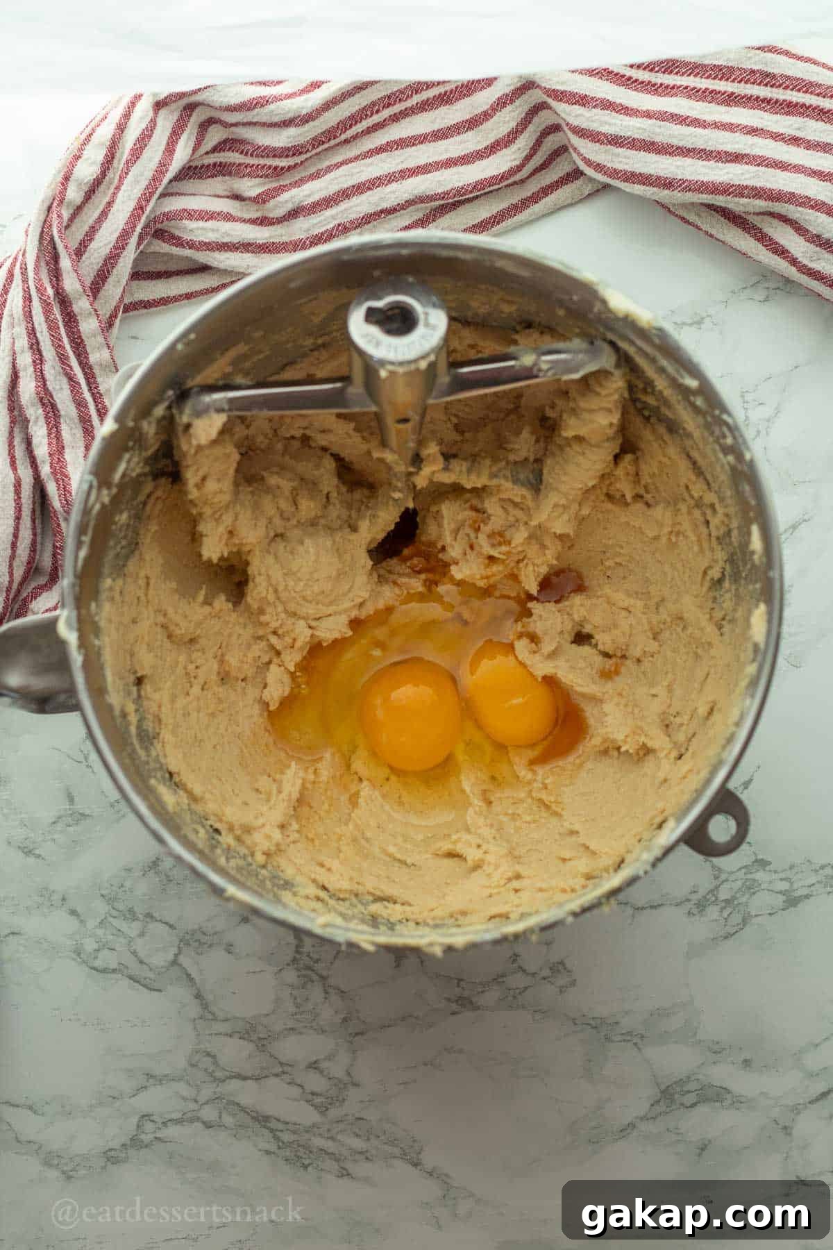 Eggs in vanilla pudding cookie dough in mixing bowl.