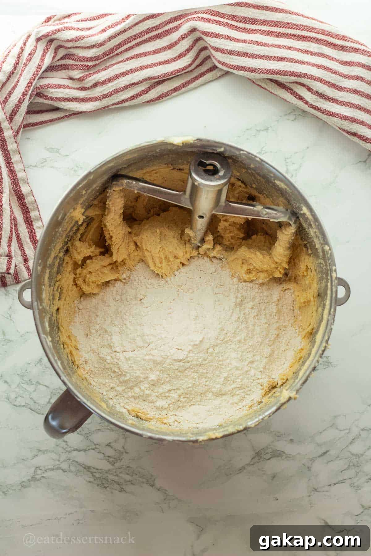 Flour in raw cookie dough in mixing bowl.