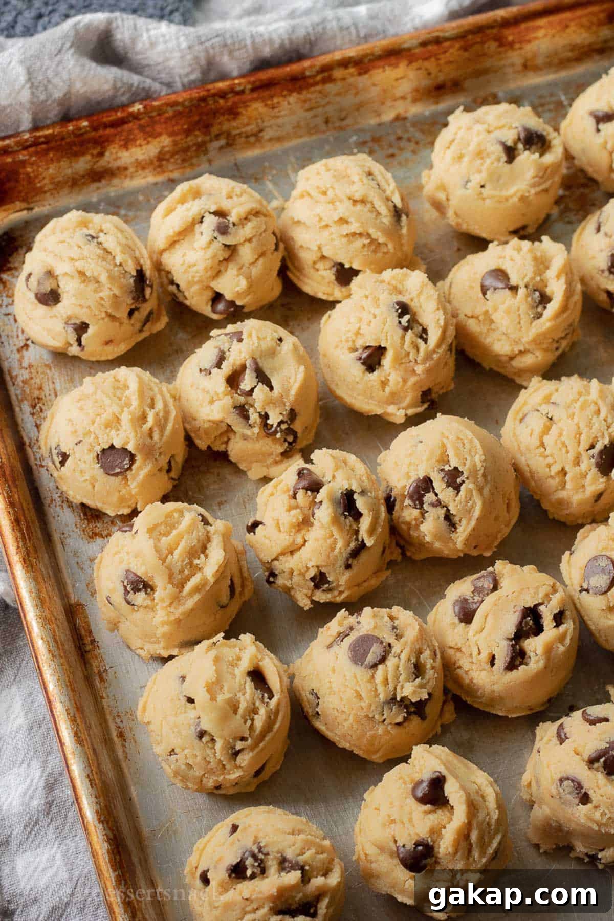 Raw cookie dough balls on baking sheet.