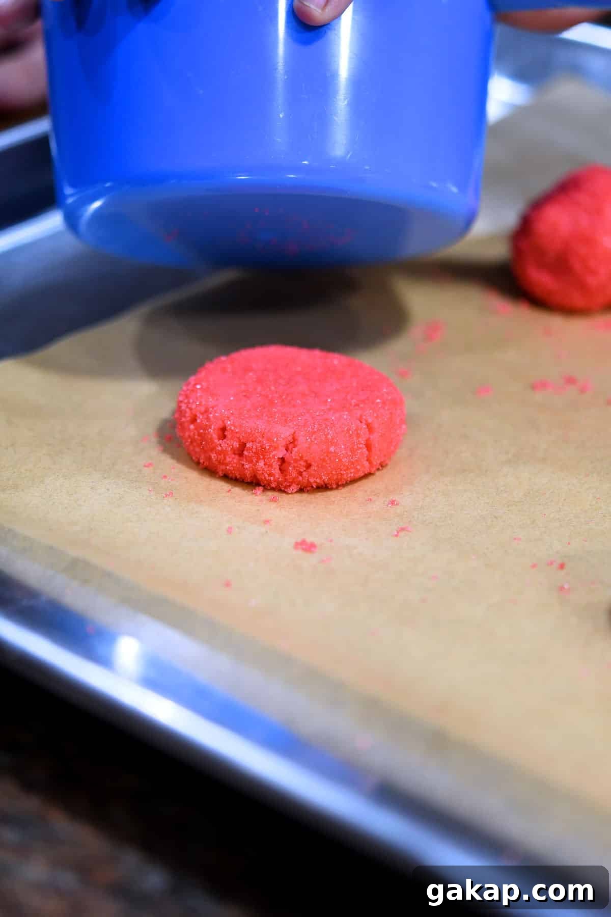 Mexican Pink Polvorones (Dye-Free Pink Cookies) 5 a ball of pink cookie dough being flattened with a measuring cup