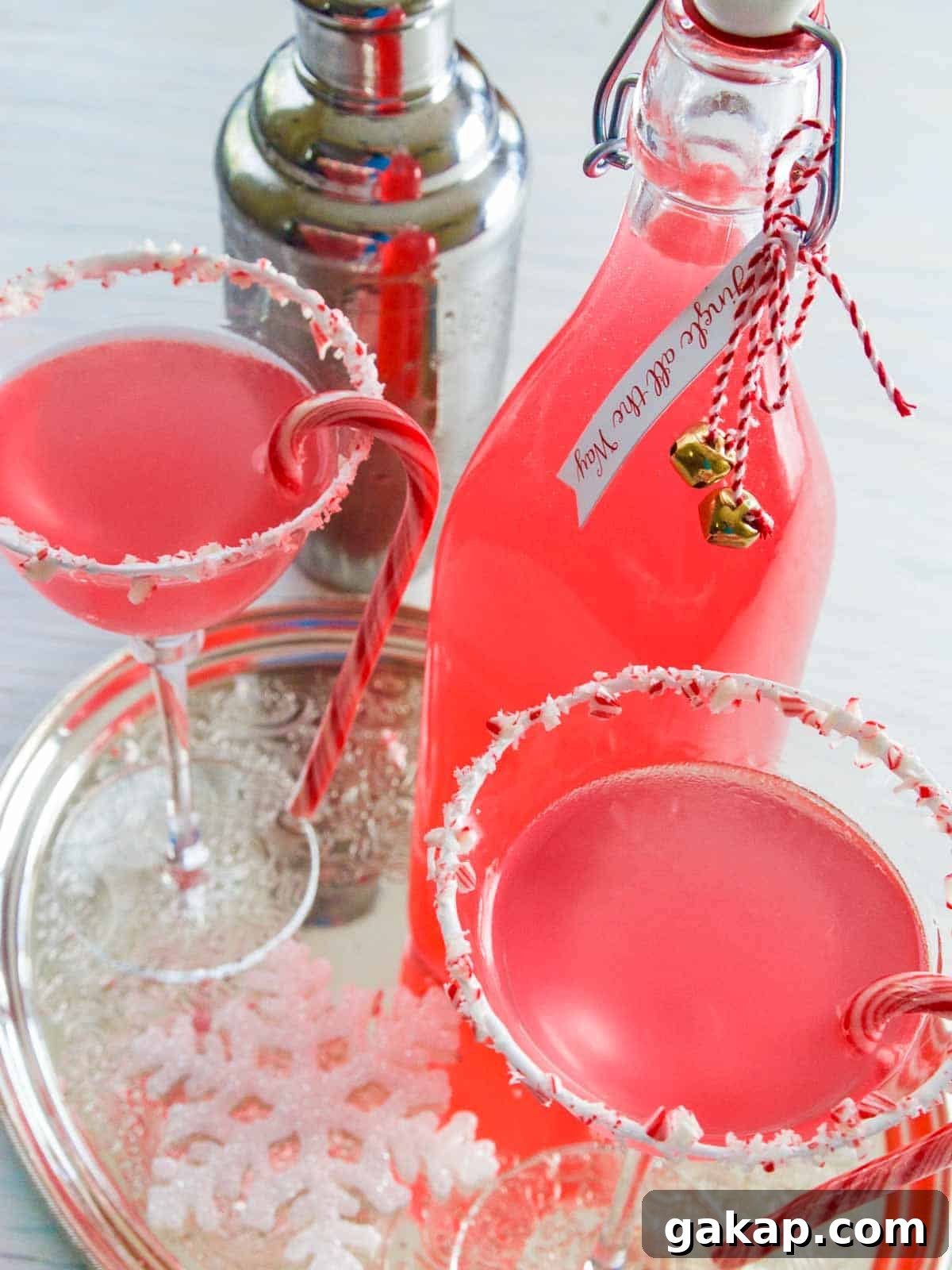Two peppermint martinis with a bottle of peppermint vodka.