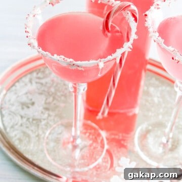 A silver tray with Candy Cane Martinis with crushed peppermint rim and candy cane garnish.