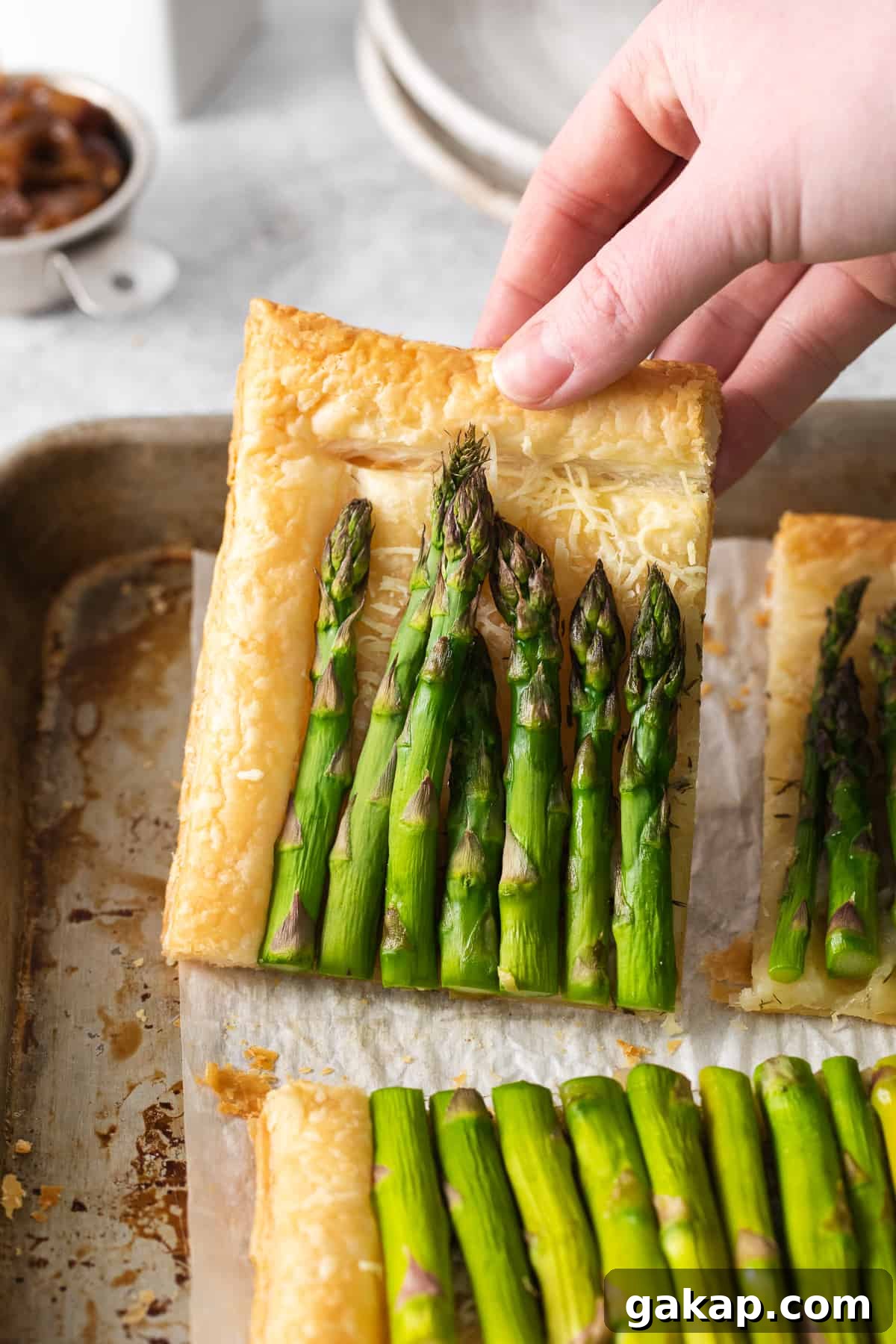 Easy asparagus tart Slice of asparagus tart on a baking sheet.