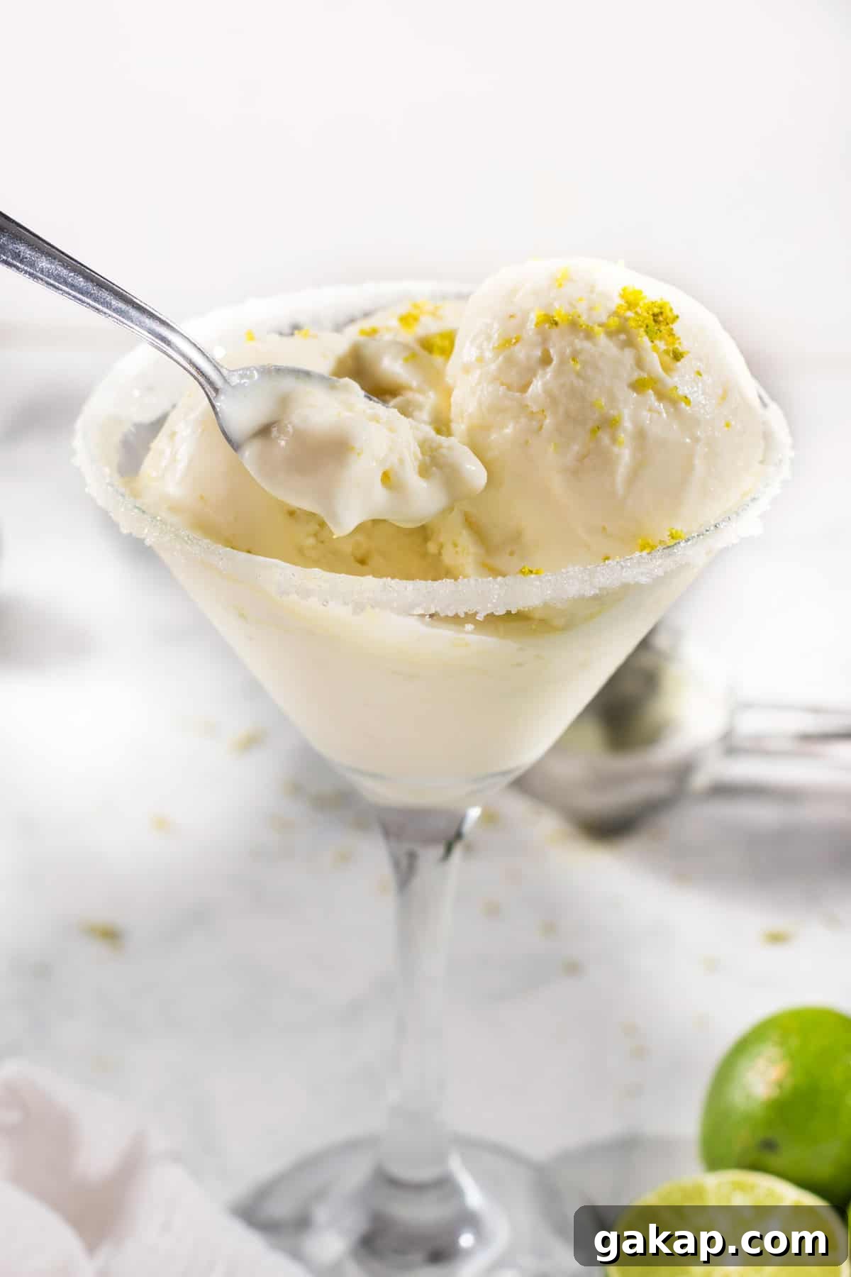 No-Churn Margarita Ice Cream: Creamy Lime & Tequila Recipe 2 Scooping out margarita ice cream with a spoon from a glass.