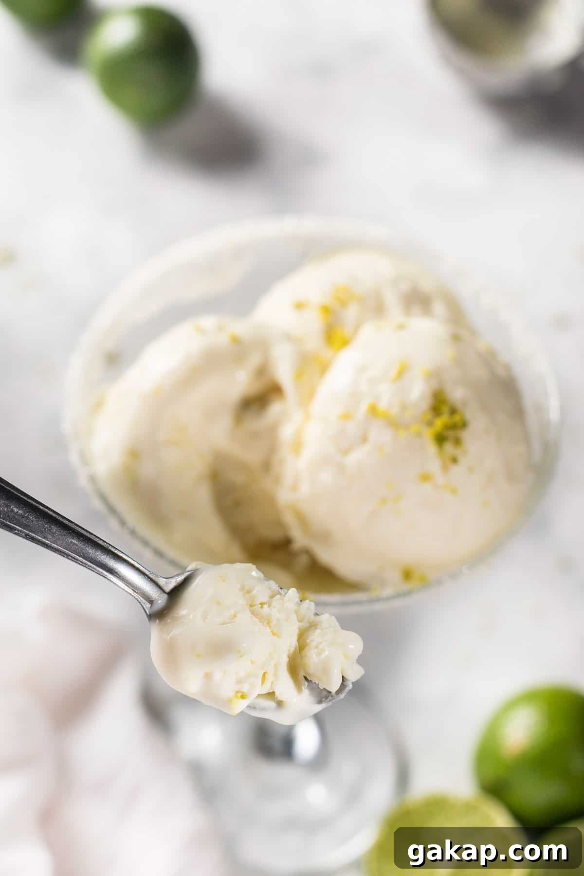 No-Churn Margarita Ice Cream: Creamy Lime & Tequila Recipe 7 Overhead view of margarita ice cream in a spoon over scoops in a glass.