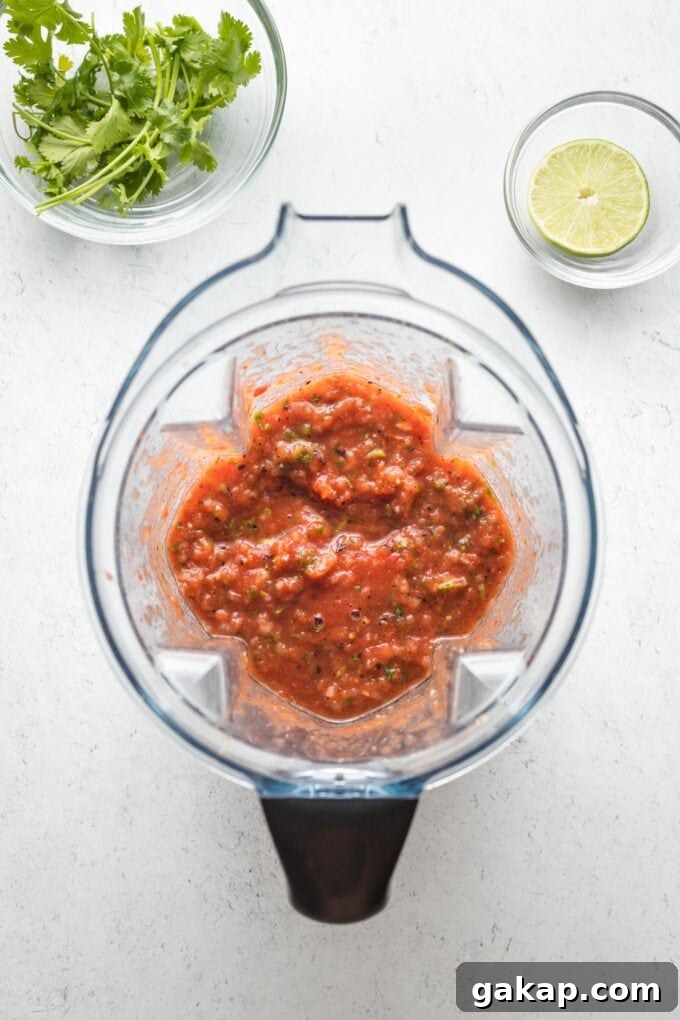 Blender with salsa ingredients, just mixed together.