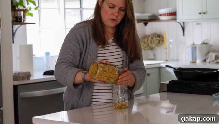 Women adding dried calendulas to a mason jar.