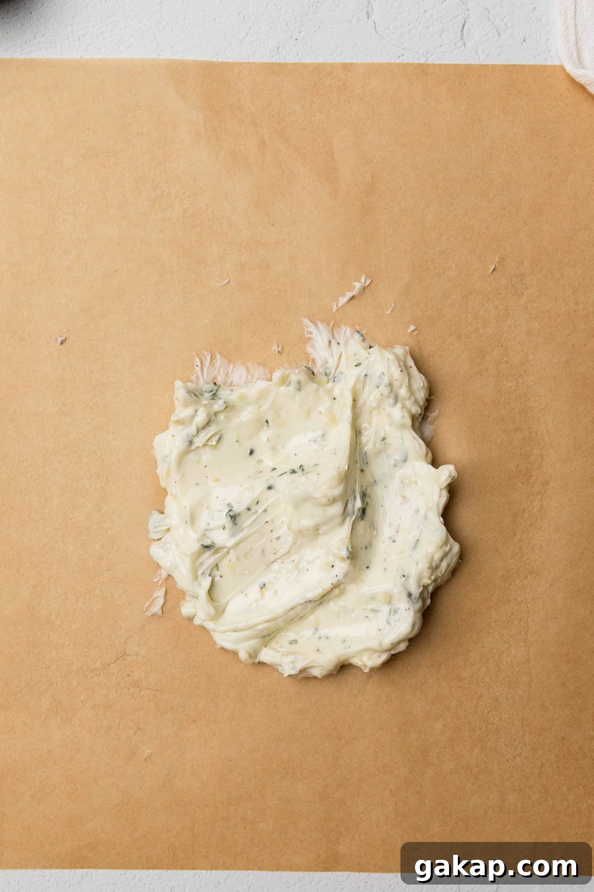 The herb garlic butter mixed up on piece of parchment paper.