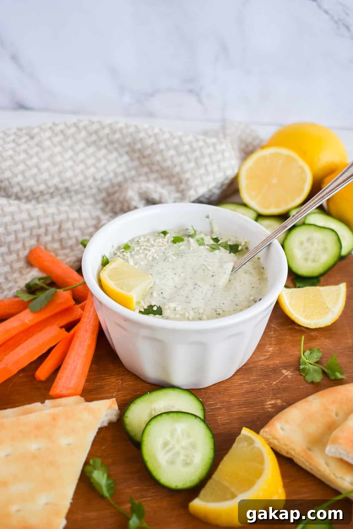 bowl of tahini sauce with vegetables on side. 
