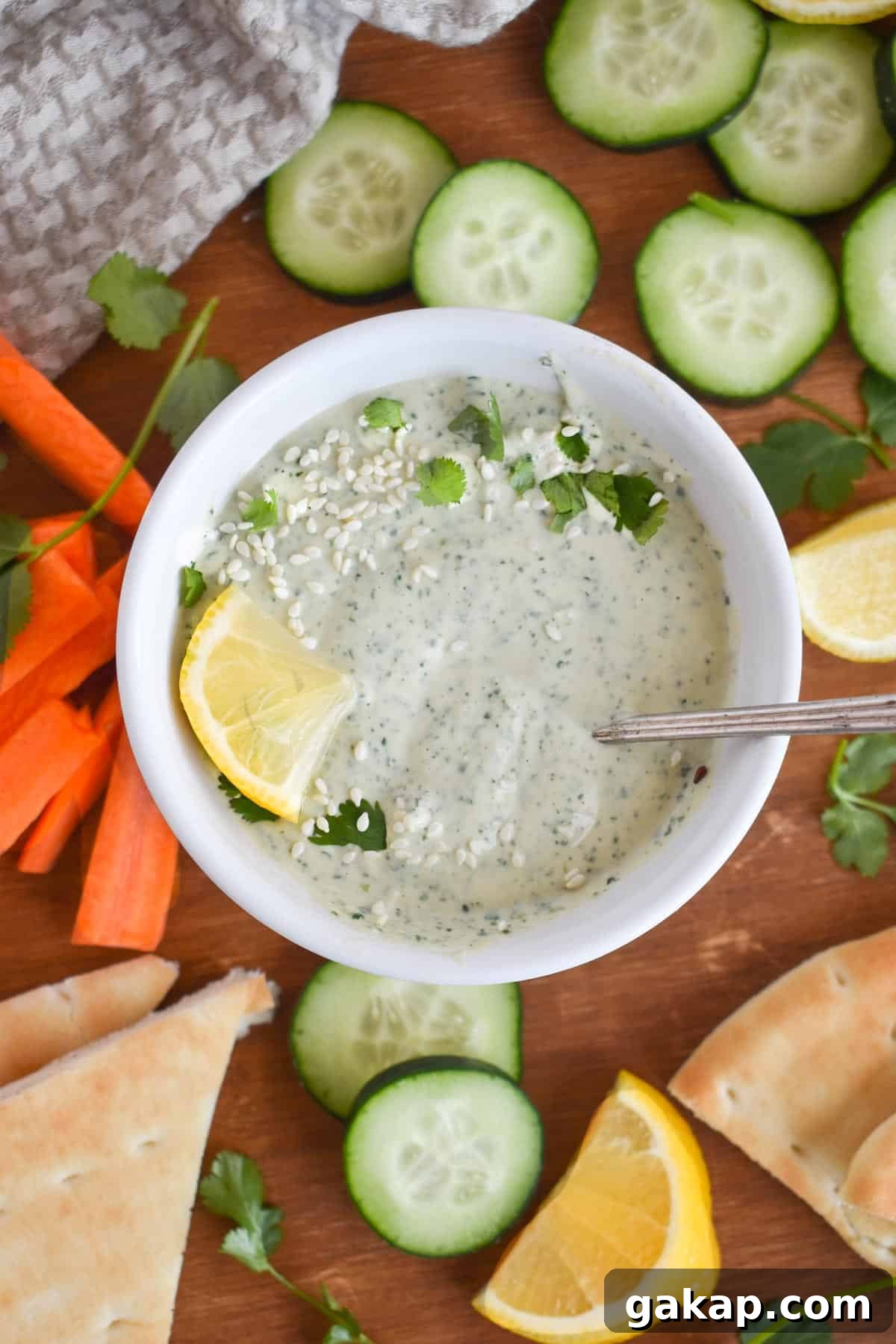 overhead show of white bowl full of lemon herb tahini. 