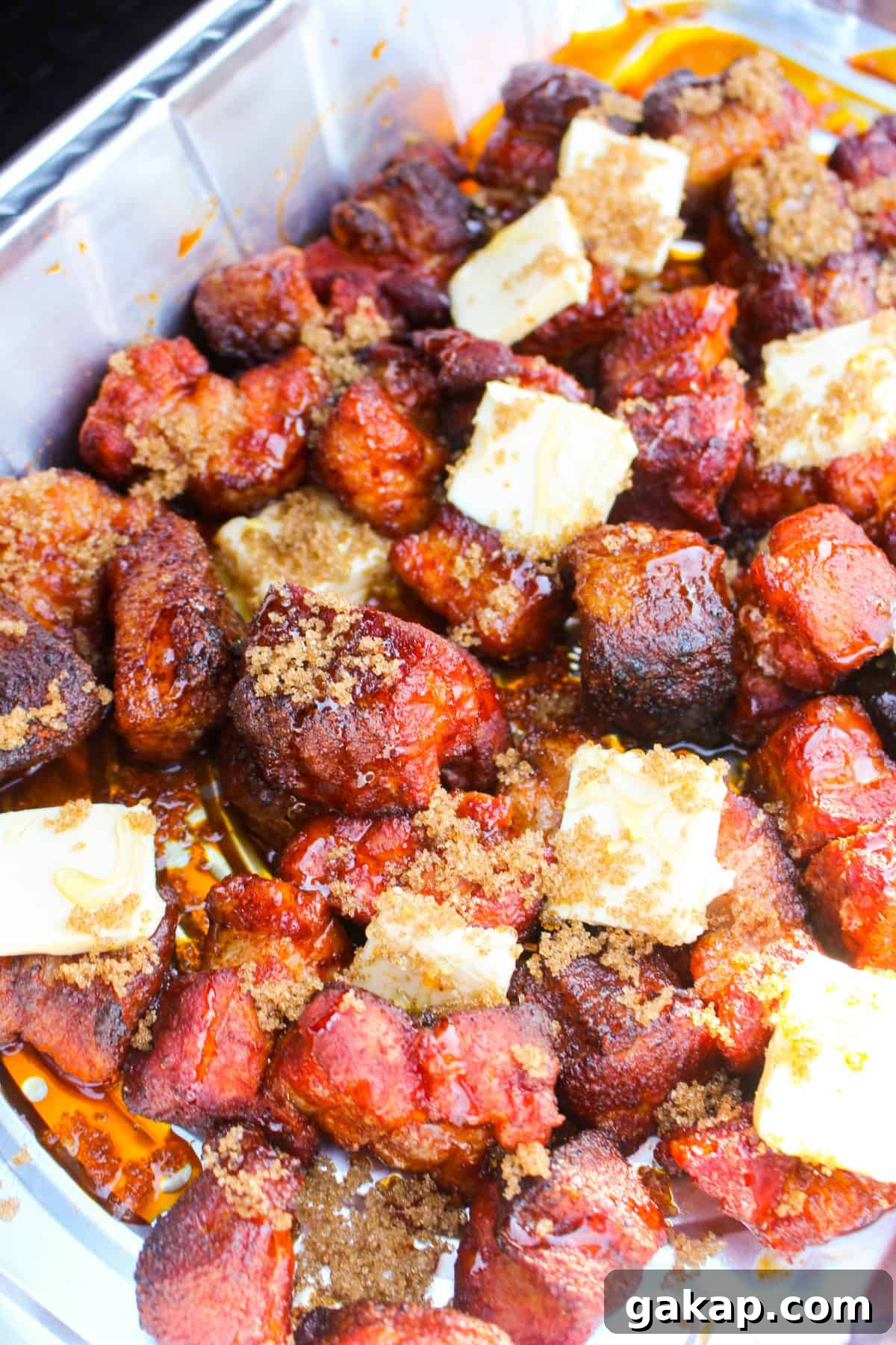 Honey Garlic Pork Belly Burnt Ends Recipe for Sticky, Crispy Bites 5 Adding butter, brown sugar and honey to the burnt ends.
