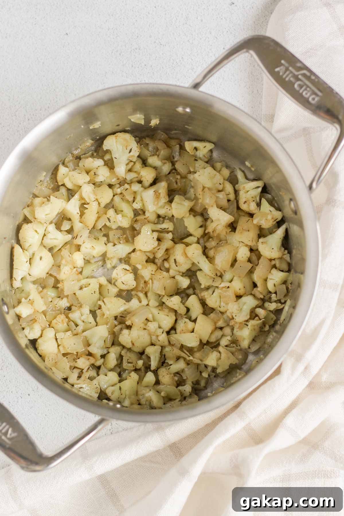 Dairy-Free, Gluten-Free Chicken Pot Pie Soup Recipe 4 Sautéed cauliflower florets and onions in a stainless steel stock pot.