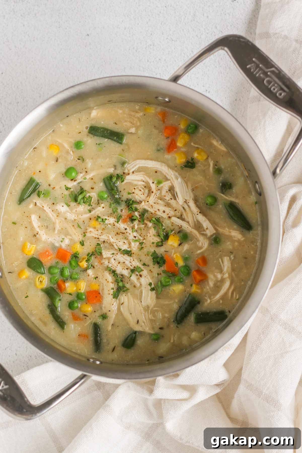 Dairy-Free, Gluten-Free Chicken Pot Pie Soup Recipe 9 Finished creamy chicken pot pie soup topped with cracked pepper in a stainless steel stock pot.