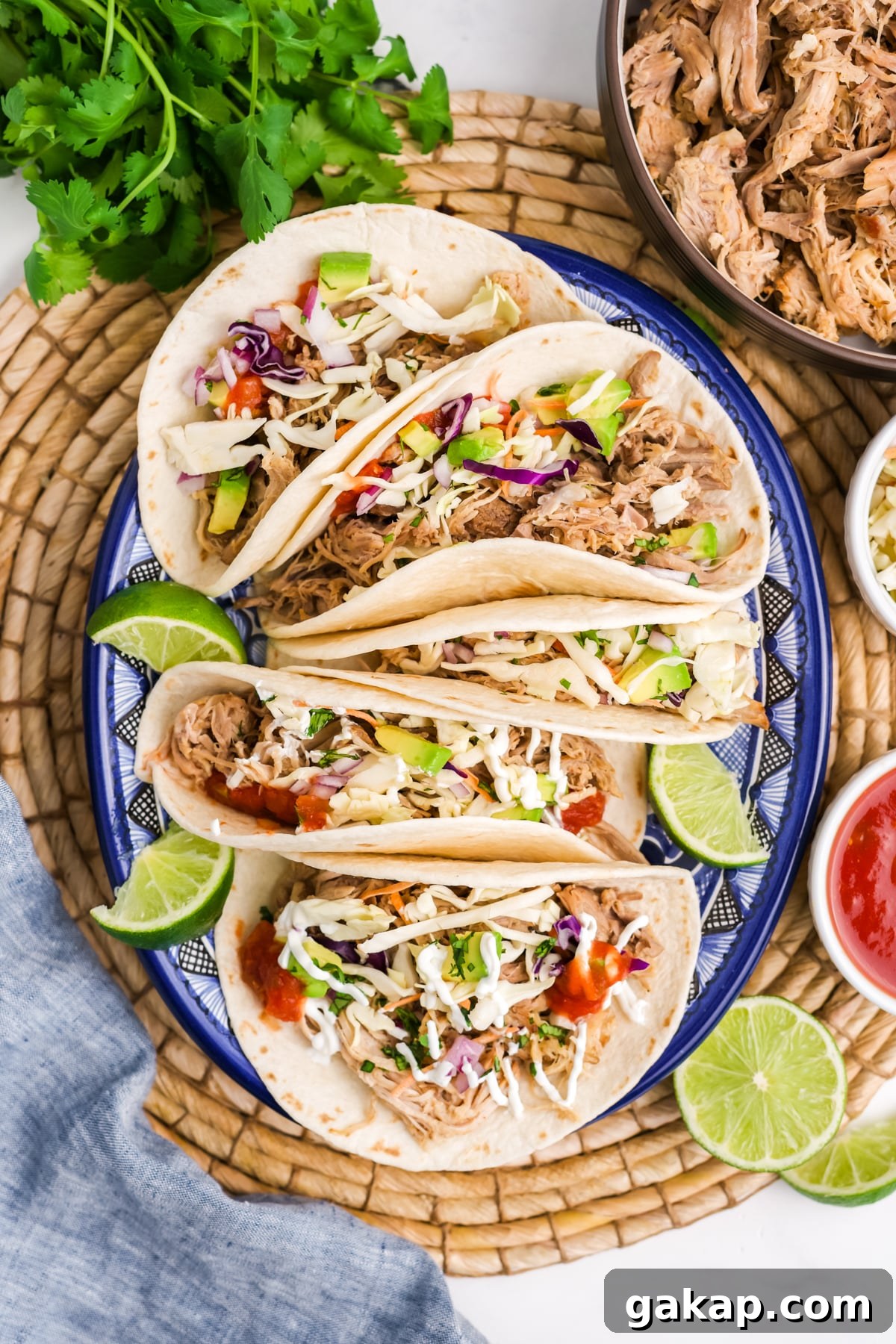 Pulled pork tacos with lime garnish on the side.