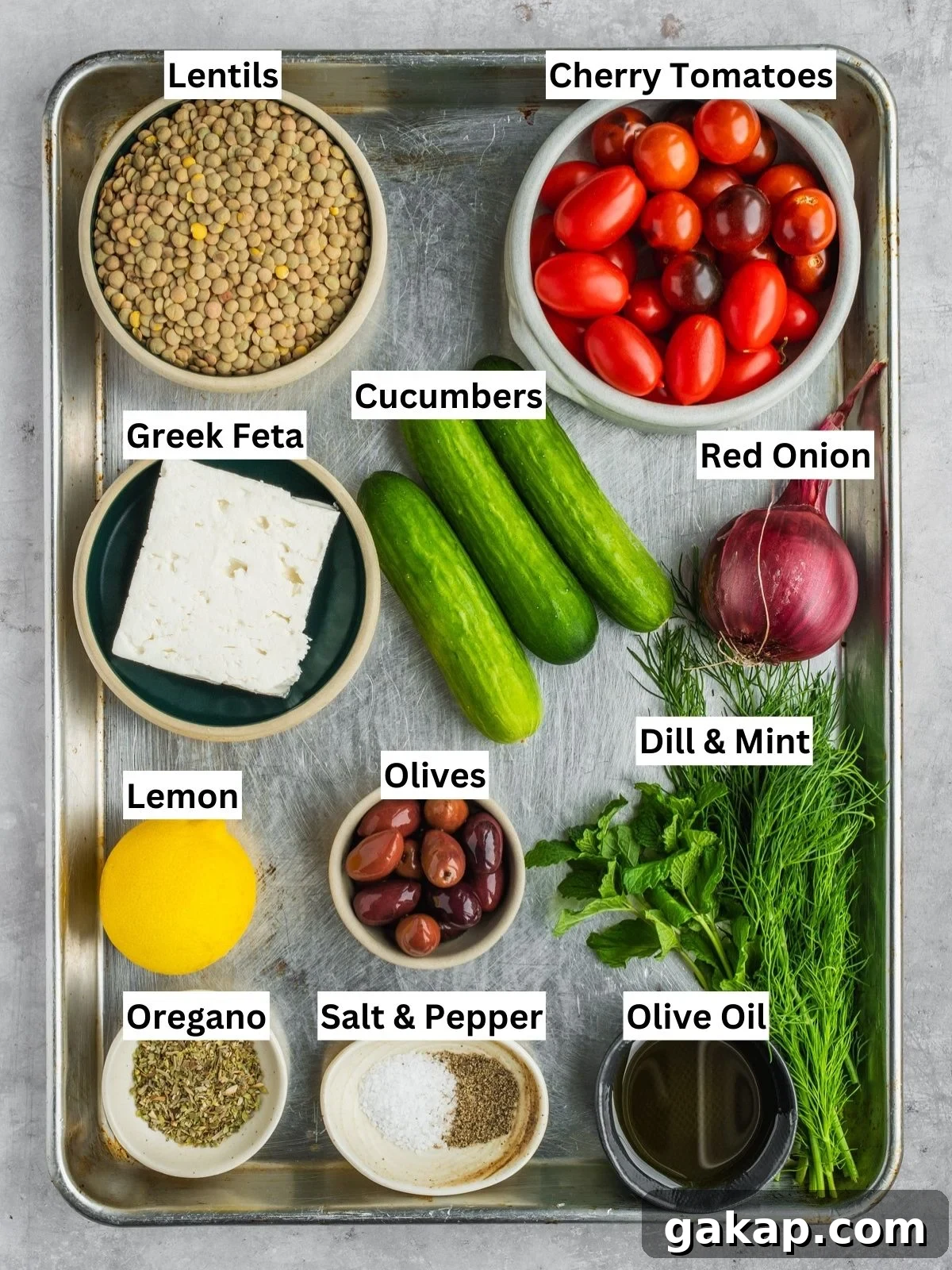 Greek-inspired lentil salad recipe ingredients with individual labels on a metal tray.