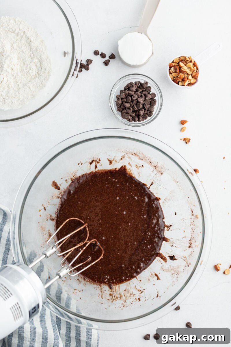 Decadent Rocky Road Brownies with Marshmallows and Nuts 6 vegetable oil, eggs, sugar, and cocoa powder mixed together in a mixing bowl