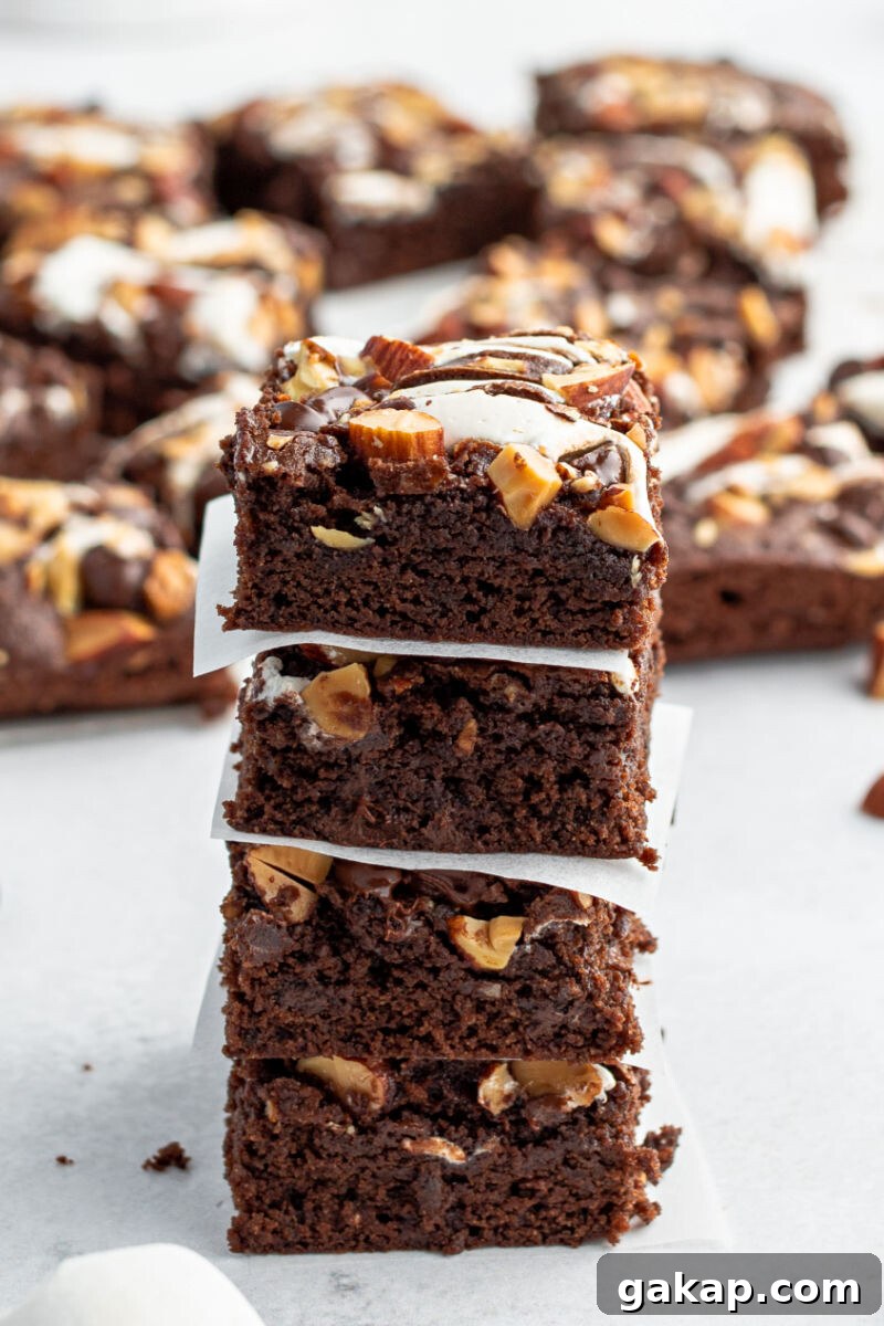 Decadent Rocky Road Brownies with Marshmallows and Nuts 10 stack of four rocky road brownies with pieces of parchment paper between each brownie