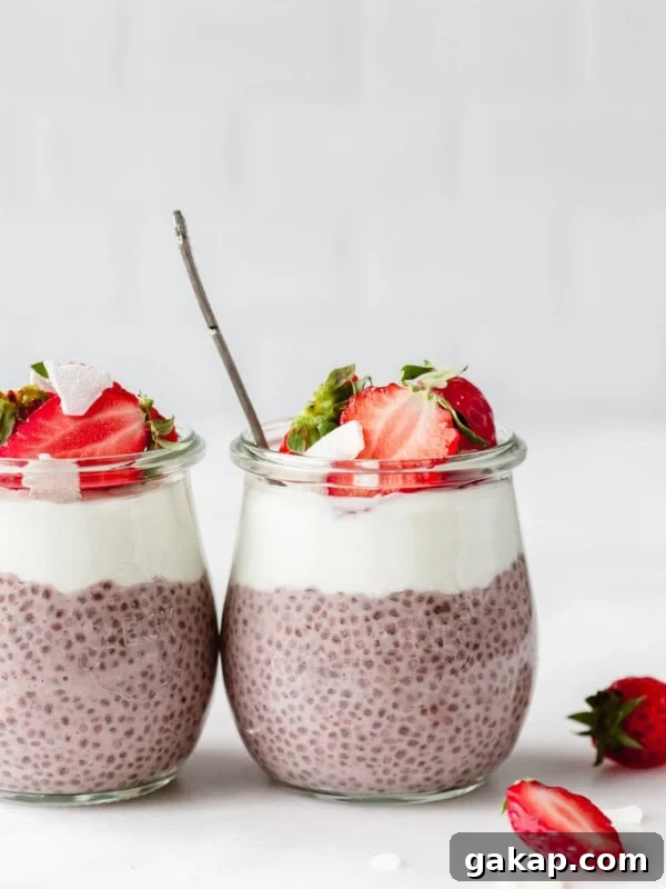 two jars of strawberry chia seed pudding topped with strawberries