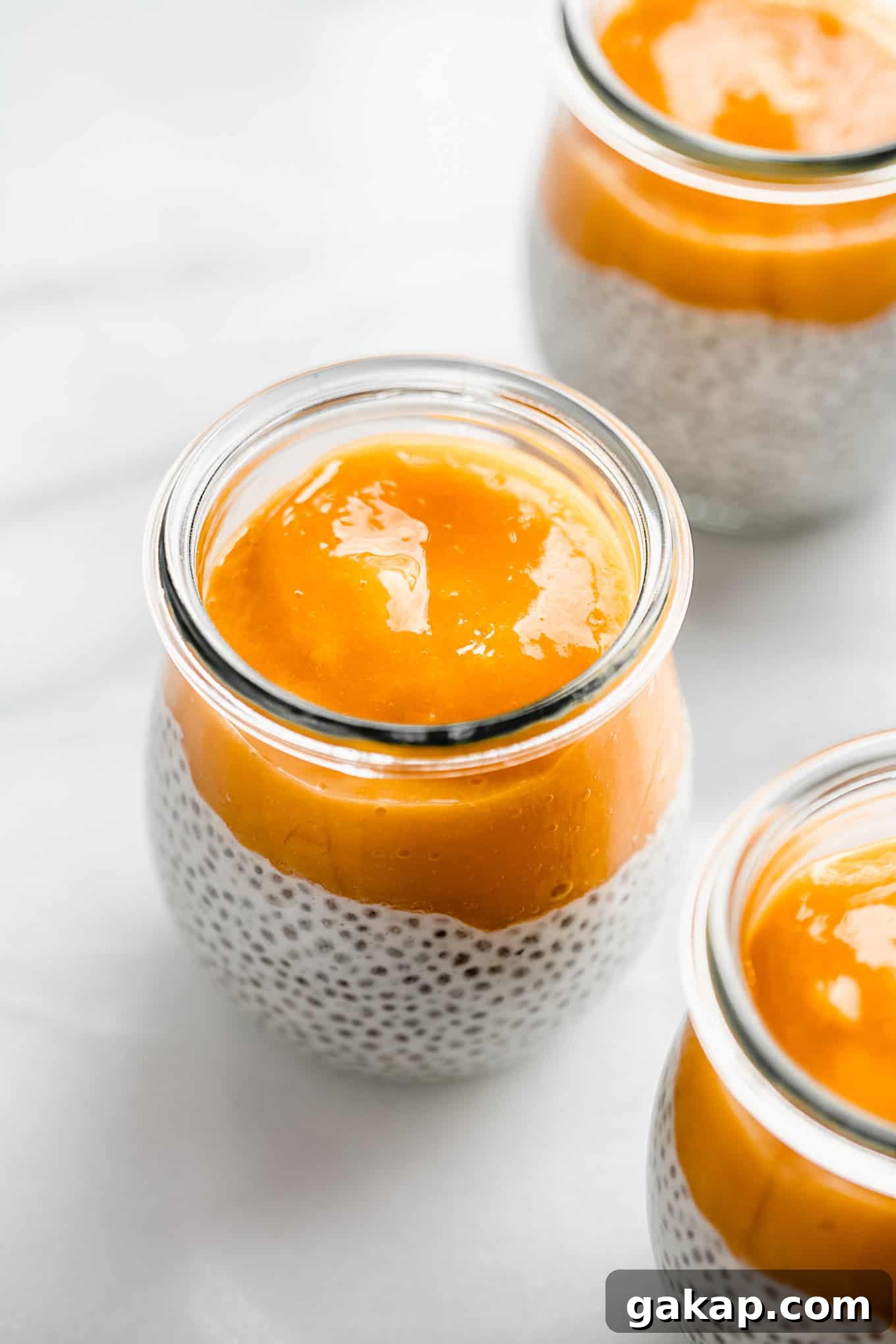 a cup of coconut chia pudding topped with mango puree.