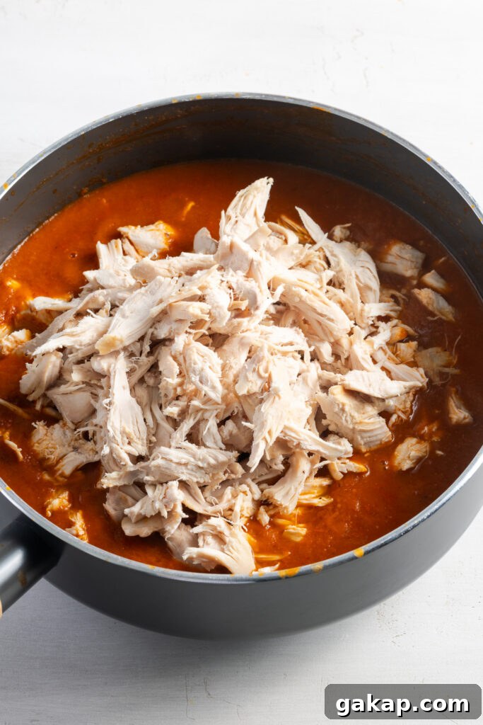 shredded cooked chicken added to the skillet with the cooked taco sauce.
