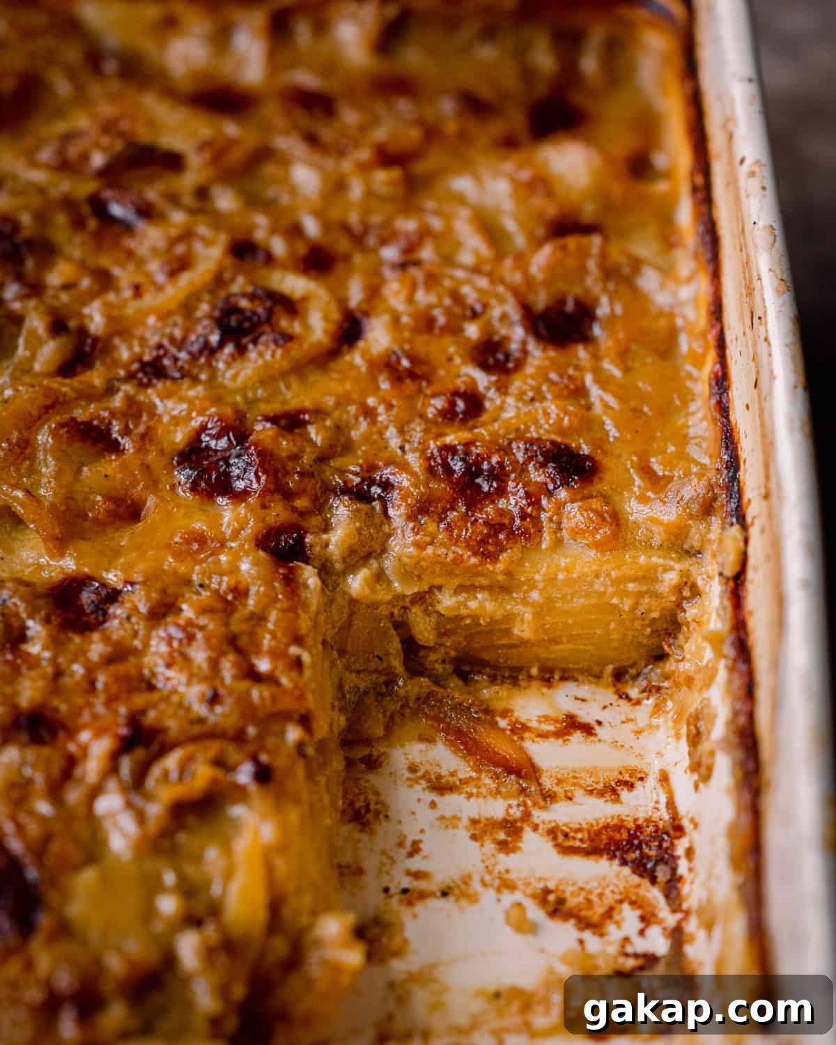 closeup shot of cheesy vegan scalloped potatoes in casserole pan