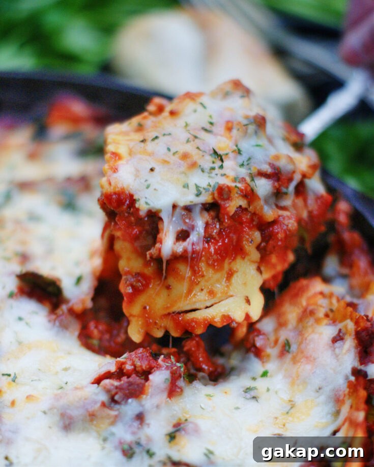 Serving a spoonful of baked ravioli with meat sauce.