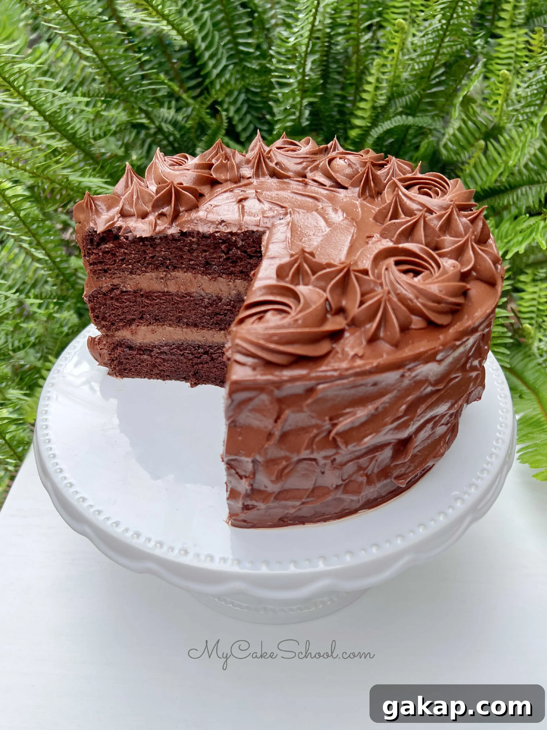 Chocolate Mousse Cake Made from Cake Mix: Quick Decadent Dessert 2 Chocolate Mousse Cake with chocolate frosting, sliced, on a white pedestal.
