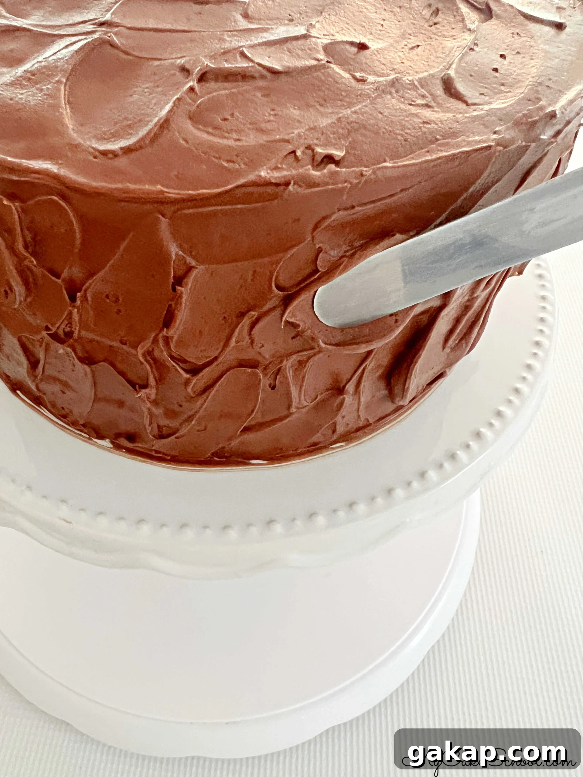 Chocolate Mousse Cake Made from Cake Mix: Quick Decadent Dessert 8 Adding texture to the frosted Chocolate Mousse Cake with an offset spatula.