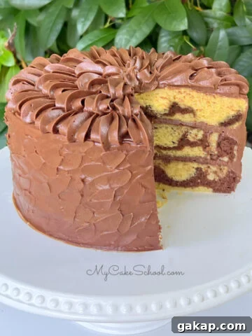 Sliced Marble Cake from cake mix, frosted with chocolate buttercream, resting on a white cake pedestal.
