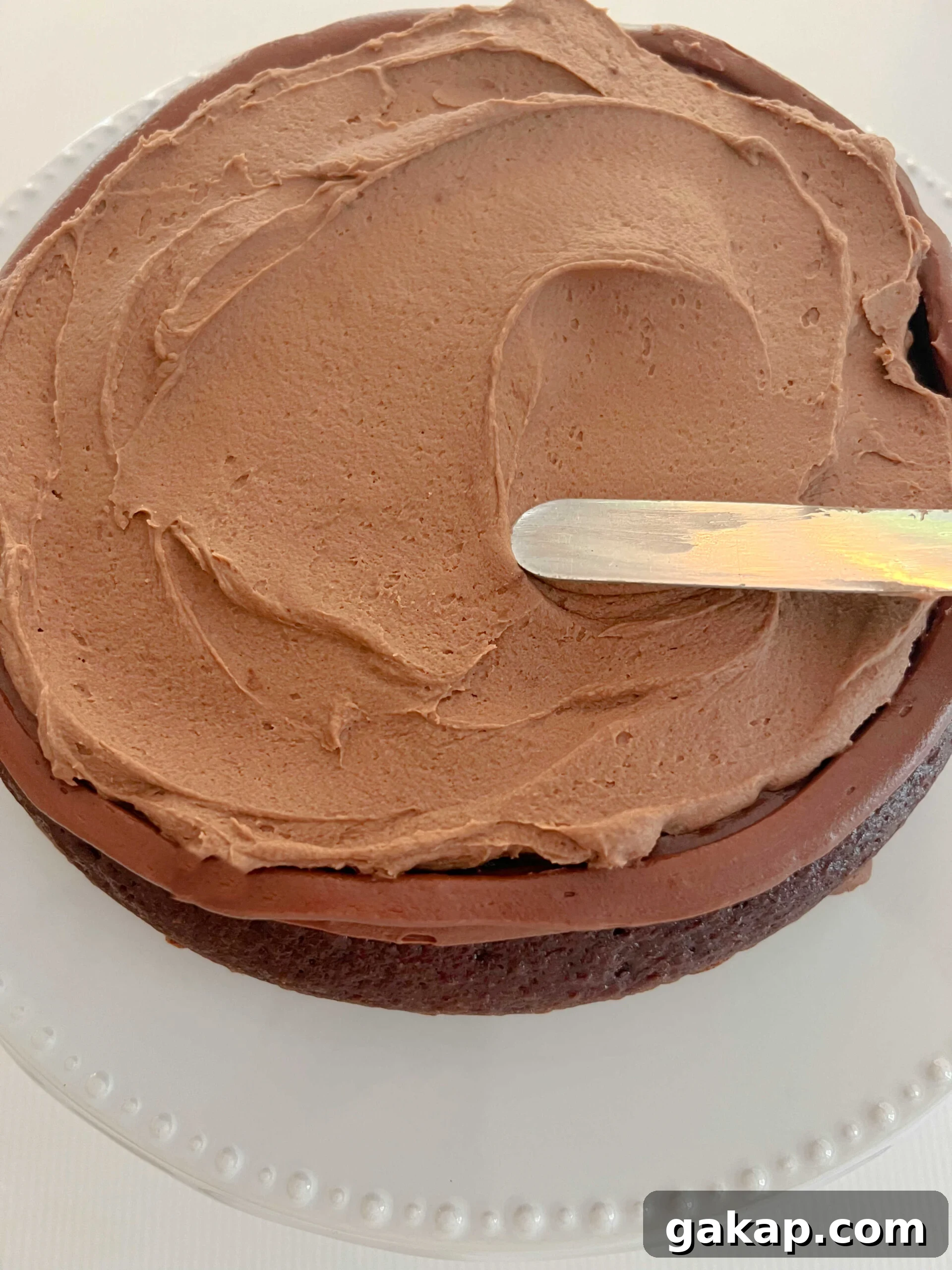 Chocolate Mousse Cake Made from Cake Mix: Quick Decadent Dessert 7 Spreading chocolate mousse filling onto cake layer.