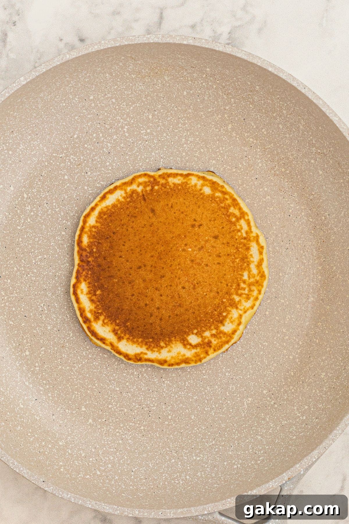 Lemon Pancakes Recipe: Fluffy Citrus Pancakes with Zesty Syrup 5 Golden pancake cooked in a skillet.