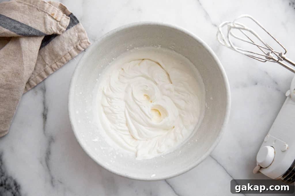Gluten-Free Gingerbread Trifle Recipe — Festive Holiday Dessert 6 Whipped cream in a bowl with beaters alongside.